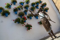 Spain, Andalucia, Cordoba, Statue of a woman watering potted plants with a cane, symbolizing the present of the Cordoba Patios party,  by artist Jose Manuel Belmonte.