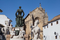 Spain, Andalucia, Cordoba, Statue of the matador Manuel Laureano Rodriguez Sanchez known as 'Manolete' on Plaza del Conde de Priego with Iglesia de Santa Maria in the background.