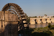 Spain, Andalucia, Cordoba, Noria on the Rio Guadalquivir with the Roman Bridge in the background.