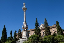Spain, Andalucia, Granada, Statue of Mariana Pineda in Jardines del Triunfo with Hospital Real in the background.