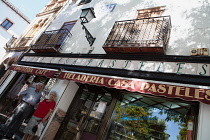 Spain, Andalucia, Granada, Elderly couple standing outside the Cafe Casa Pasteles on Plaza Larga in the Albayzin district.