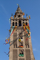 Spain, Andalucia, Seville, The Giralda of Seville Cathedral with banners and streamers hanging from the bell  tower to celebrate the feast of Corpus Christi.