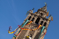 Spain, Andalucia, Seville, The Giralda of Seville Cathedral with banners and streamers hanging from the bell  tower to celebrate the feast of Corpus Christi.