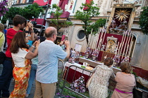 Spain, Andalucia, Seville, Worshippers take photographs of the temporary shrine in front of the Iglesia Colegial Divino Salvador that is on display to celebrate the feast of Corpus Christi.