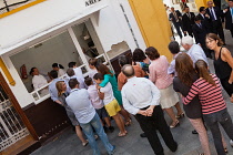 Spain, Andalucia, Seville, Customers queuing to buy churros at a shop in the El Arenal disctrict of Seville.