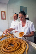 Spain, Andalucia, Seville, A cook prepares a helping of churros.