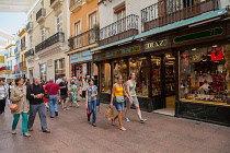 Spain, Andalucia, Seville, Boutiques on Calle Sierpes in the central shopping district of Seville. Diaz on the right sells typical Spanish items including hand painted Spanish fans &  silk embroidered...