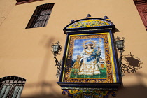 Spain, Andalucia, Seville, Tiled ceramic image of St Anne on the wall of Iglesia de Santa Ana in the Triana district.