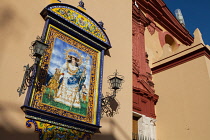 Spain, Andalucia, Seville, Tiled ceramic image of St Anne on the wall of Iglesia de Santa Ana in the Triana district.