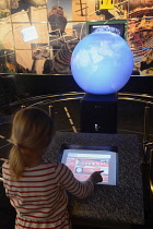 Scotland, Edinburgh, Our Dynamic Earth, child using interactive display with globe.