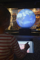 Scotland, Edinburgh, Our Dynamic Earth, child using interactive display with globe.