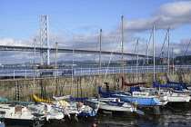 Scotland, Edinburgh, South Queensferry, harbour with boats & Forth Road Bridge in distance.