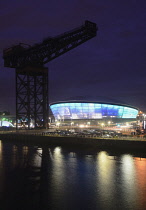 Scotland, Glasgow, The Clyde, The Hydro arena lit at night with Finnieston crane.