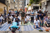 Turkey, Istanbul, Muslims praying during Friday prayers in a street near Taksim Square.