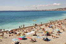 France, Nice, Baie Des Anges and tourists sunbathing on beach.