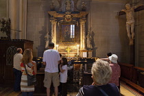 Croatia, Zagreb, Old town, Catholic cathedral interior with worshippers lighting candles.