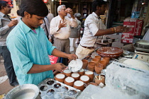 India, Delhi, Serving lassi in clay pots in the old city of Delhi.