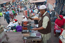 India, Delhi, Cooking lamb kebabs over a charcoal fire in the old city of Delhi.