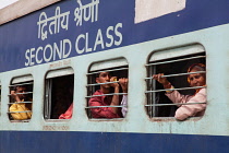 India, Haryana, Rohtak, Passengers at the windows of a second class train at Rohtak railway station.