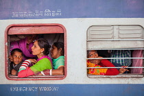 India, Haryana, Rohtak, Passengers at the windows of a second class train at Rohtak railway station.