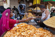 India, Rajasthan, Bikaner, Vendor selling namkeen, chat and savoury snacks in the market at Bikaner.