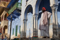 India, Rajasthan, Pushkar, A man stands underneath the arches of a Haveli in the old town of Pushkar.