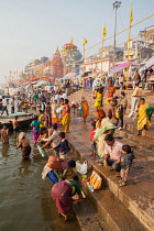 India, Uttar Pradesh, Varanasi, Pilgrims on the ghats beside the Ganges at Varanasi.