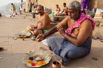India, Uttar Pradesh, Varanasi, Male members from a bereaved family perform puja on the ghats beside the Ganges in Varanasi.