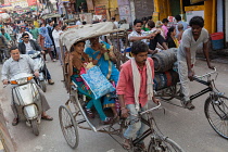 India, Uttar Pradesh, Varanasi, Cycle rickshaws and motorcyclists in Varanasi.