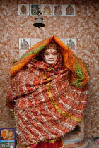 India, Uttar Pradesh, Varanasi, A statue of Vishnu wrapped in a textile offering left by a devotee .