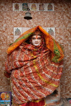 India, Uttar Pradesh, Varanasi, A statue of Vishnu wrapped in a textile offering left by a devotee .