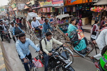 India, Uttar Pradesh, Varanasi, Cycle rickshaws and motorcyclists in Varanasi.