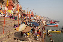 India, Uttar Pradesh, Varanasi, Pilgrims on the ghats beside the Ganges at Varanasi.
