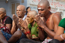 India, Uttar Pradesh, Varanasi, A bereaved family perform puja on the ghats at Varanasi after the cremation of a deceased relative.