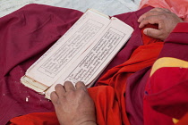 India, Bihar, Bodhgaya, Prayer cards in the lap of a monk at the Mahabodhi Temple in Bodhgaya.
