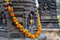 India, Bihar, Bodhgaya, Garland of marigolds wrapped around a stupa at the Mahabodhi Temple in Bodhgaya.