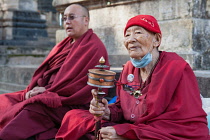 India, Bihar, Bodhgaya, Buddhist monk with a prayer wheel at the Mahabodhi Temple in Bodhgaya.
