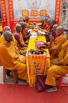 India, Bihar, Bodhgaya, Monks praying at the Mahabodhi Temple in Bodhgaya.