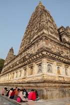 India, Bihar, Bodhgaya, Pilgrims praying at the base of the Mahabodhi Temple in Bodhgaya.