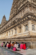 India, Bihar, Bodhgaya, Pilgrims praying at the base of the Mahabodhi Temple in Bodhgaya.