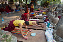 India, Bihar, Bodhgaya, Buddhist monks praying and prostrating themselves at the Mahabodhi Temple in Bodhgaya.