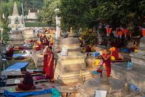India, Bihar, Bodhgaya, Buddhist monks praying and prostrating themselves at the Mahabodhi Temple in Bodhgaya.