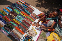 India, Tamil Nadu, Mahabalipuram, A vendor arranges a display of beaded necklaces for sale at the entrance to the Shore Temple in Mahabalipuram.