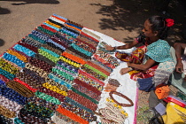 India, Tamil Nadu, Mahabalipuram, A vendor arranges a display of beaded necklaces for sale at the entrance to the Shore Temple in Mahabalipuram.