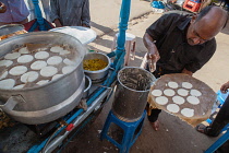 India, Telengana, Secunderabad, Man making idlis at a food stall in Secunderabad.