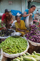 India, Telengana, Secunderabad, Vendor selling aubergines and cucumbers at the vegetable market in Secunderabad.