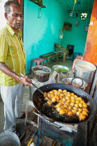 India, Andhra Pradesh, Armoor, Food hotel vendor frying chilli bhajis.