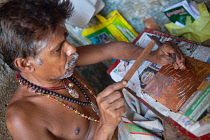 India, Tamil Nadu, Madurai, A tinker engraving a brass sheet in his workshop in Madurai.