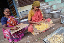 India, Tamil Nadu, Tiruchirappalli, Trichy, Women winnowing maize in the market at Trichy.