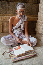 India, Tamil Nadu, Tiruchirappalli, Trichy, A saddhu reading sacred text at the Sri Ranganathaswamy Temple in Srirangam near Tiruchirappalli.